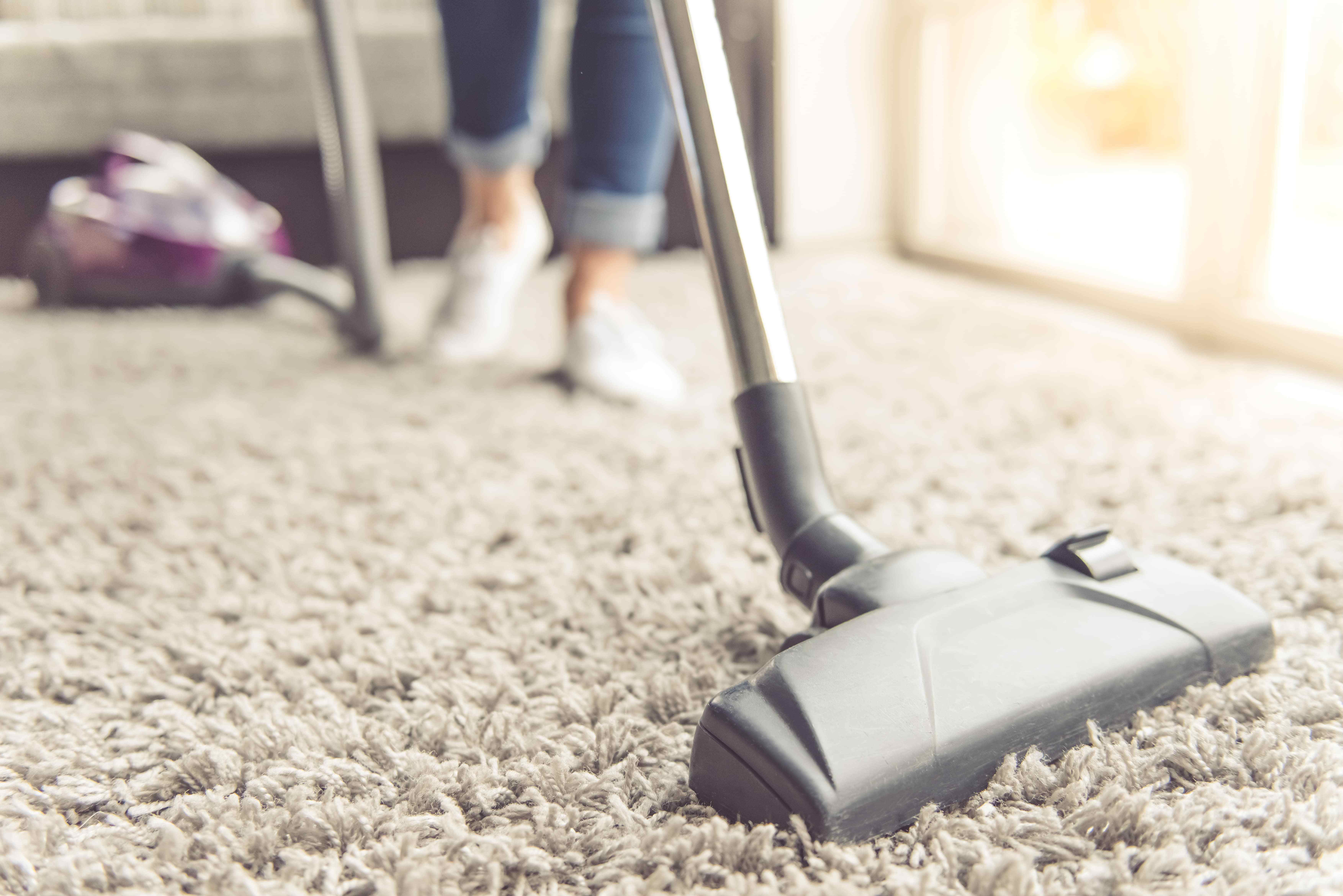 person vacuuming rug