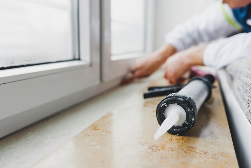 sealing a window sill with caulk