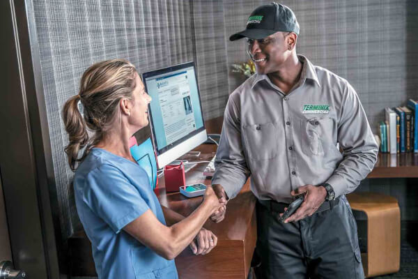 Terminix tech shaking healthcare workers hand