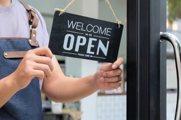 Person flipping open sign