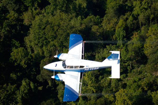 airplane flying over trees