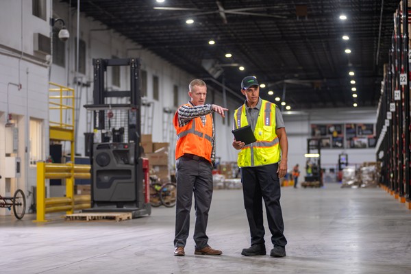 Terminix tech talking to warehouse manager in a warehouse