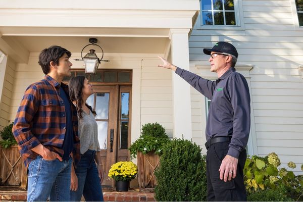 Terminix technician pointing at area with homeowners