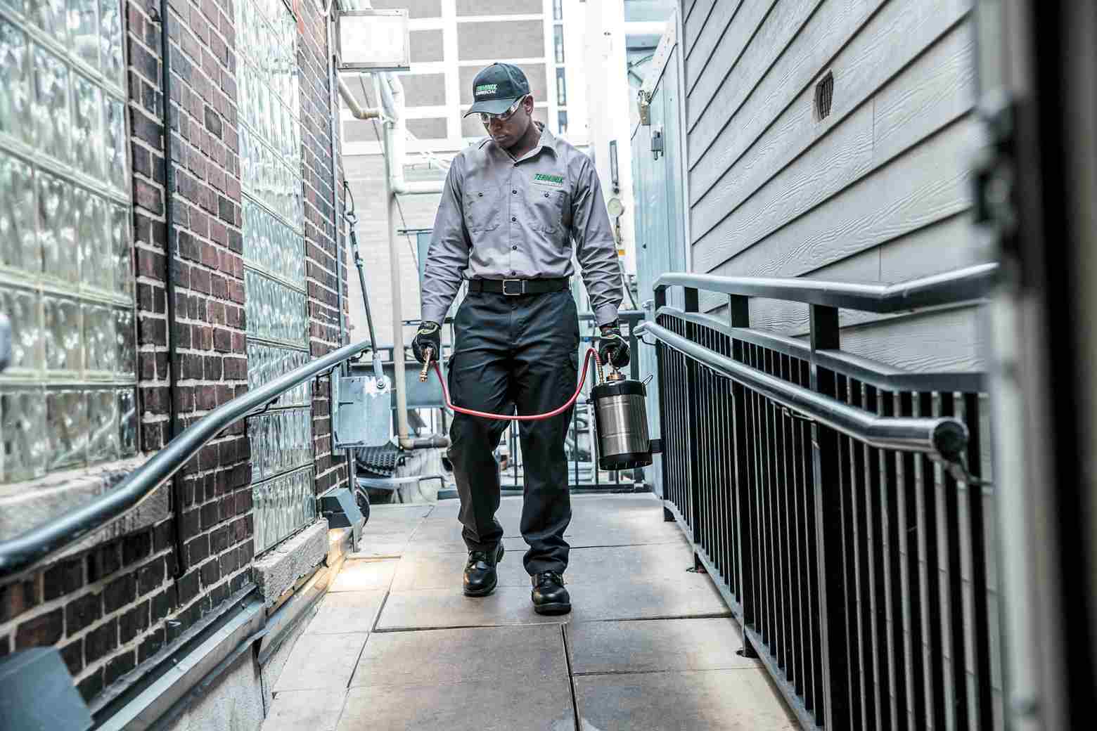 technician spraying outside of business