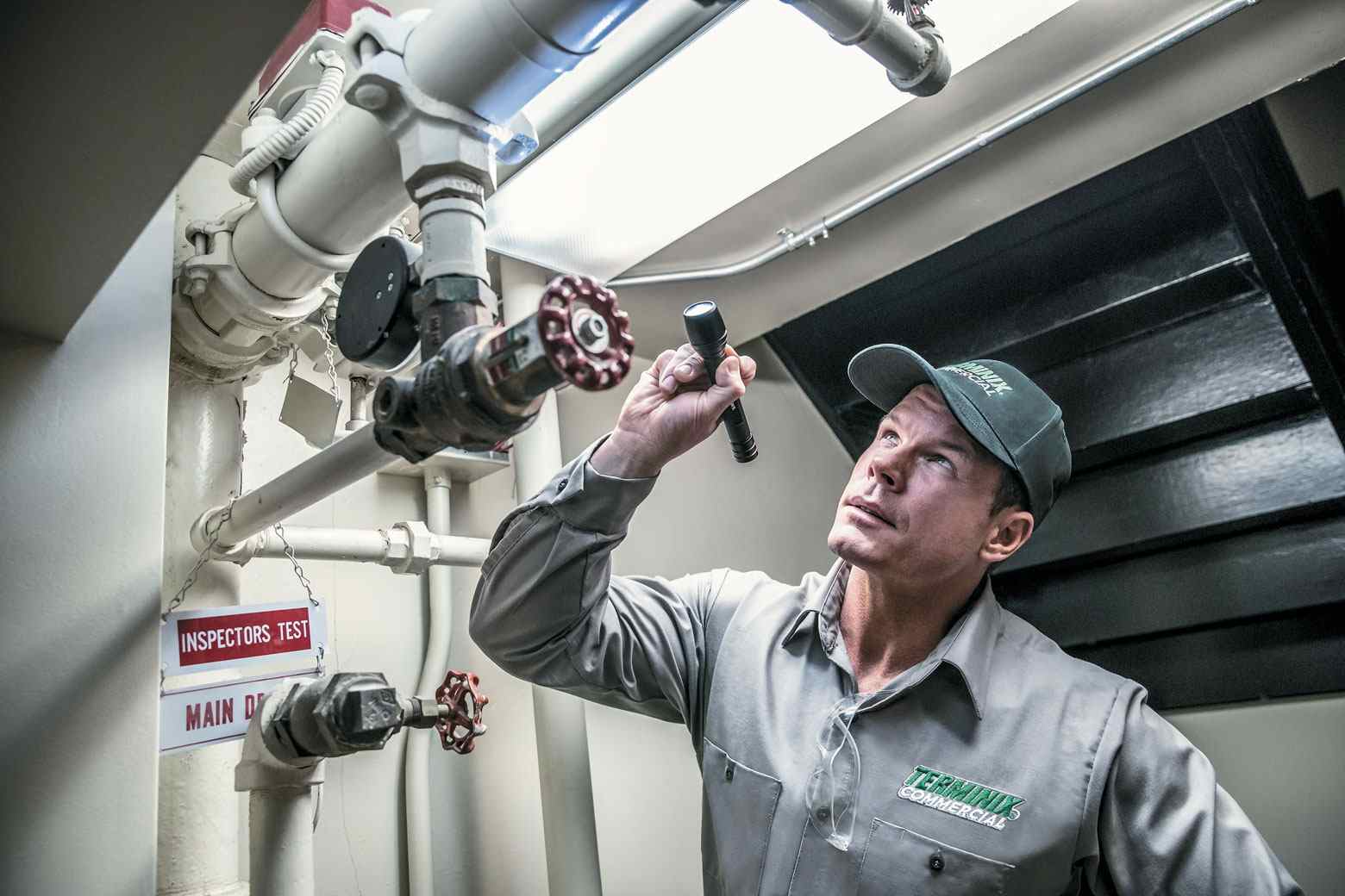 terminix technician looking at pipes