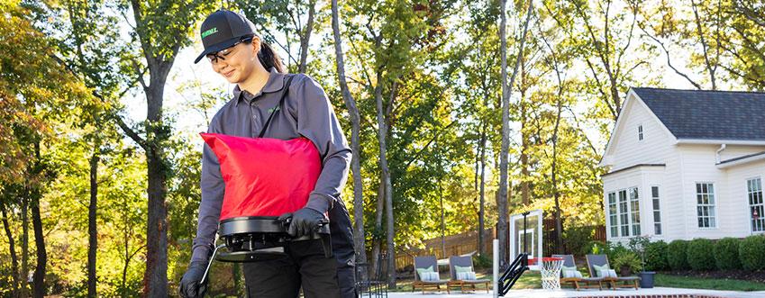 Technician performing tick control in a customer's yard