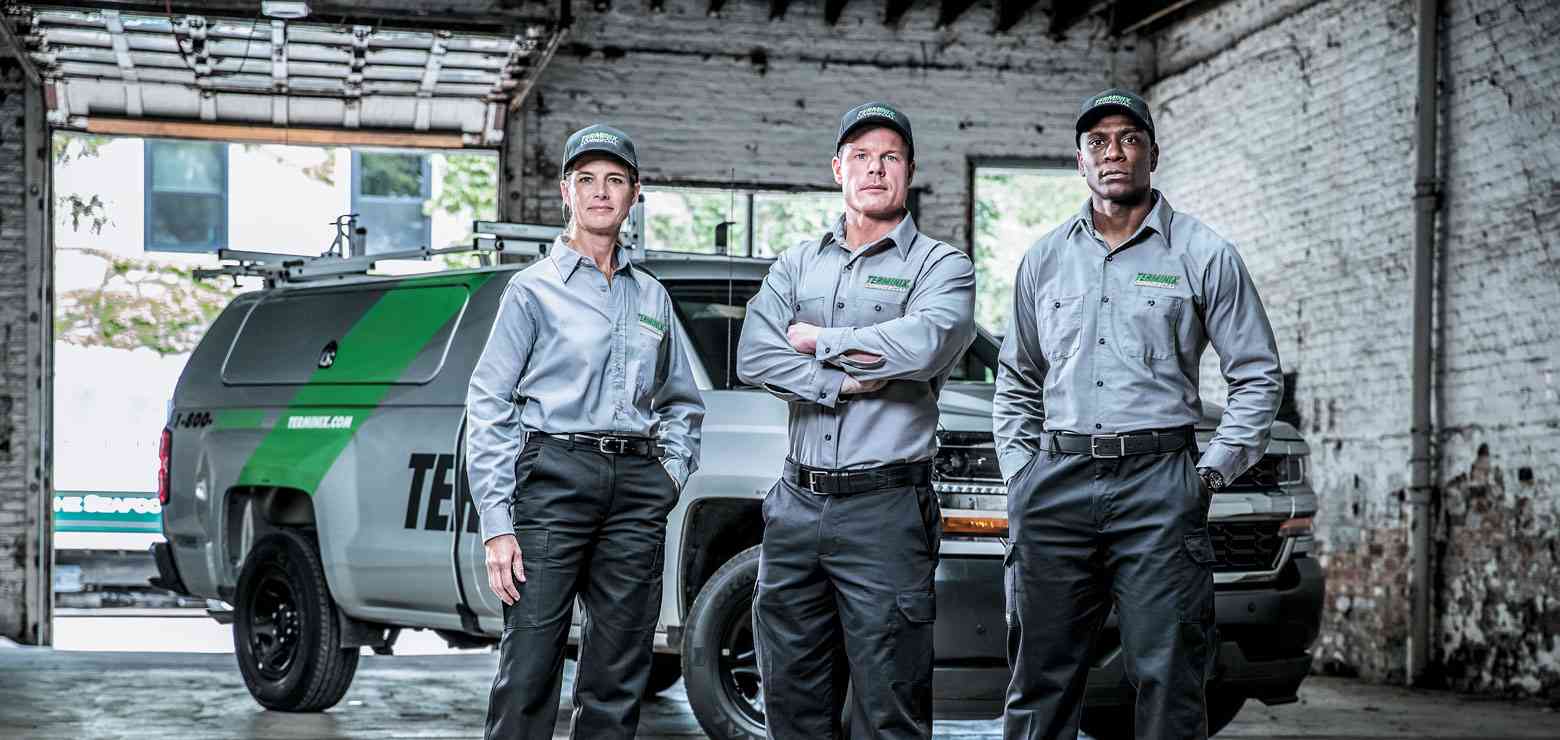 three terminix technicians in front of terminix truck
