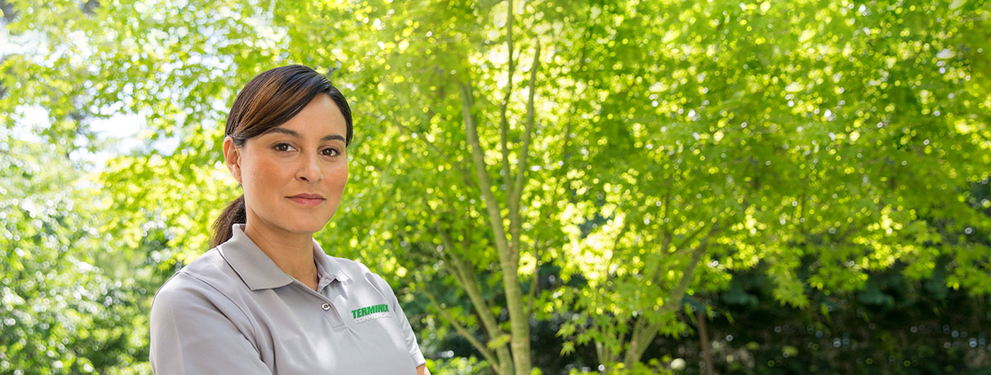 Terminix technician with green trees in background