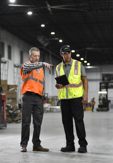 Terminix tech consulting with warehouse manager inside a warehouse