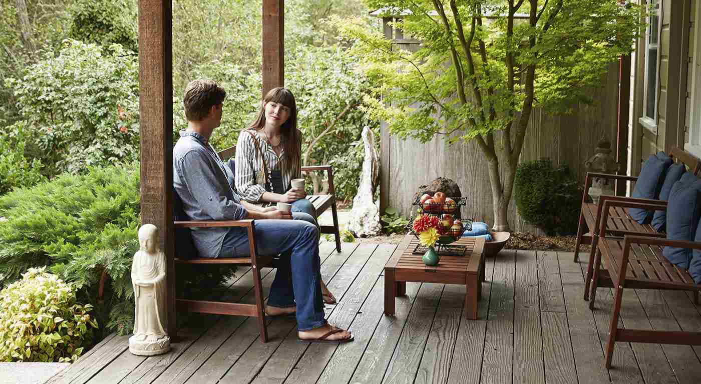 Man and woman sitting outside on a porch talking to each other