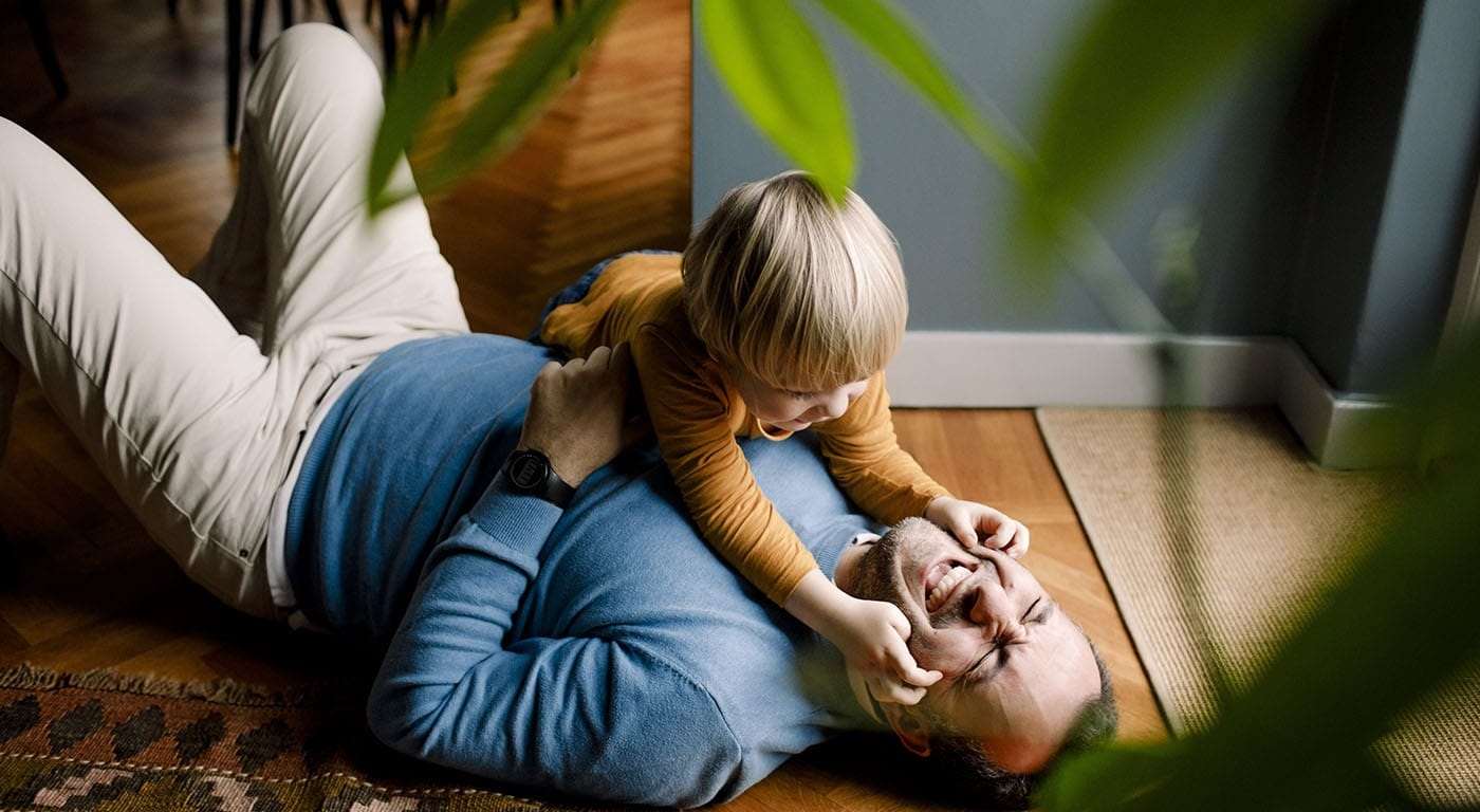 dad and son playing on ground in house
