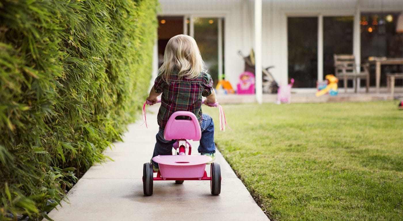 back of child head riding a tricycle