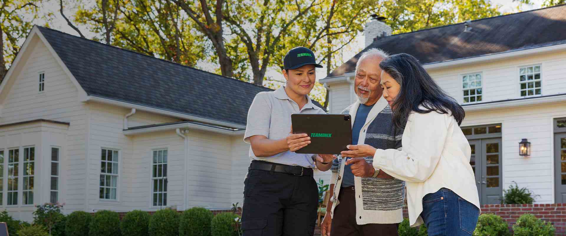 Terminix technician talking with new homeowners outside their home