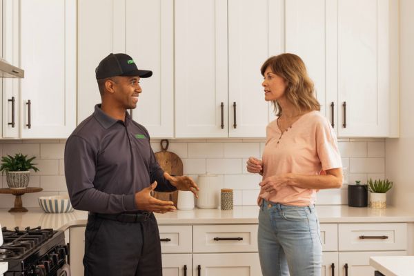 Terminix technician talking with a customer in a kitchen
